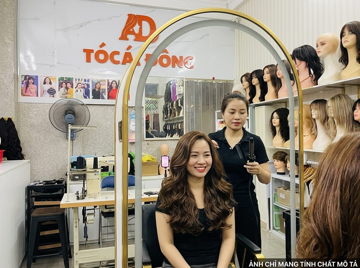 Khách hàng trải nghiệm uốn nhiệt tạo kiểu và nhuộm màu tùy biến trực tiếp trên bộ tóc giả nguyên bản tại Tóc Á Đông